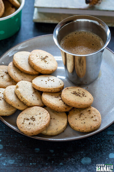 ajwain cookies in a plate with a glass of coffee