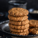 stack of oats jaggery cookies with a cup in the background
