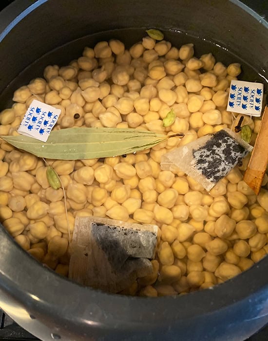 chickpeas with whole spices and tea bags in pressure cooker