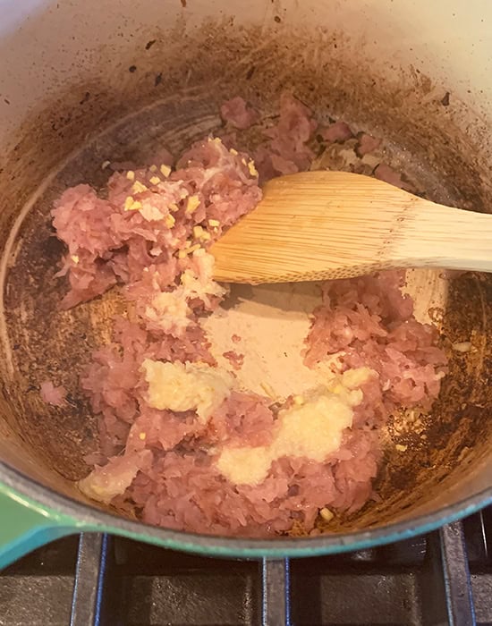 onions with ginger garlic getting cooked in a pot