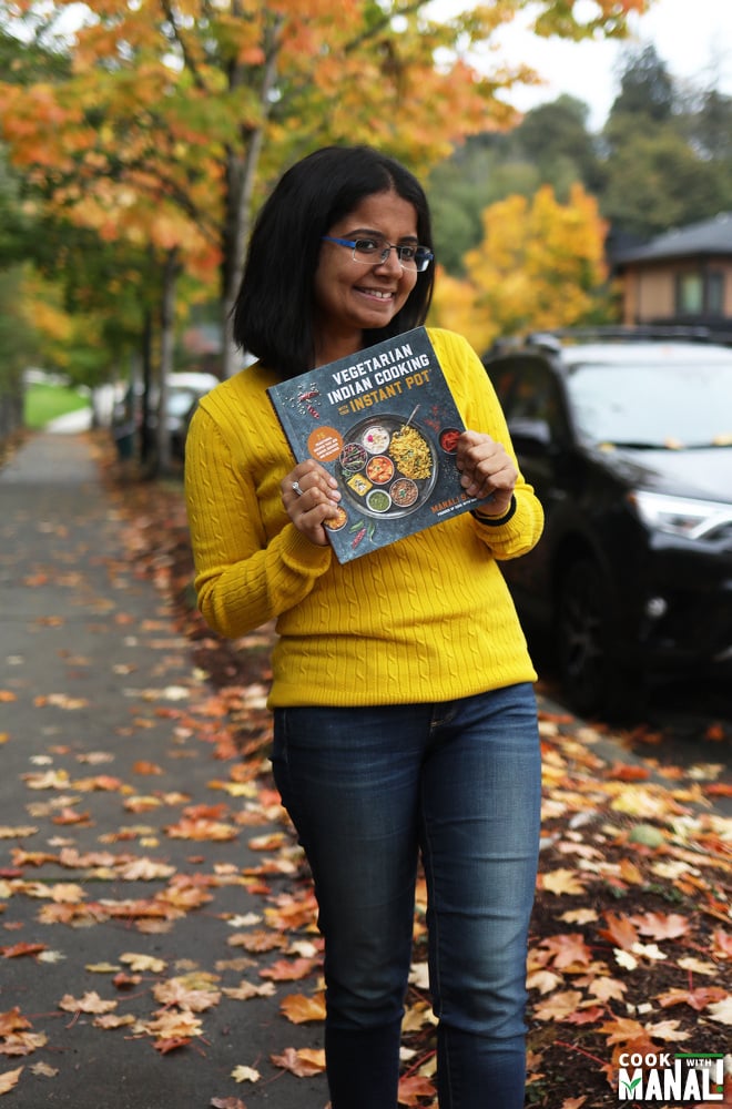 manali holding a copy of her cookbook