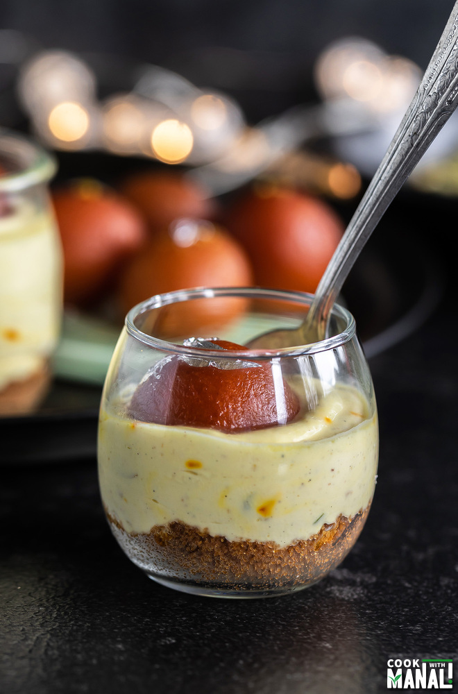 small glass jar filled with shrikhand and topped with gulab jamun 