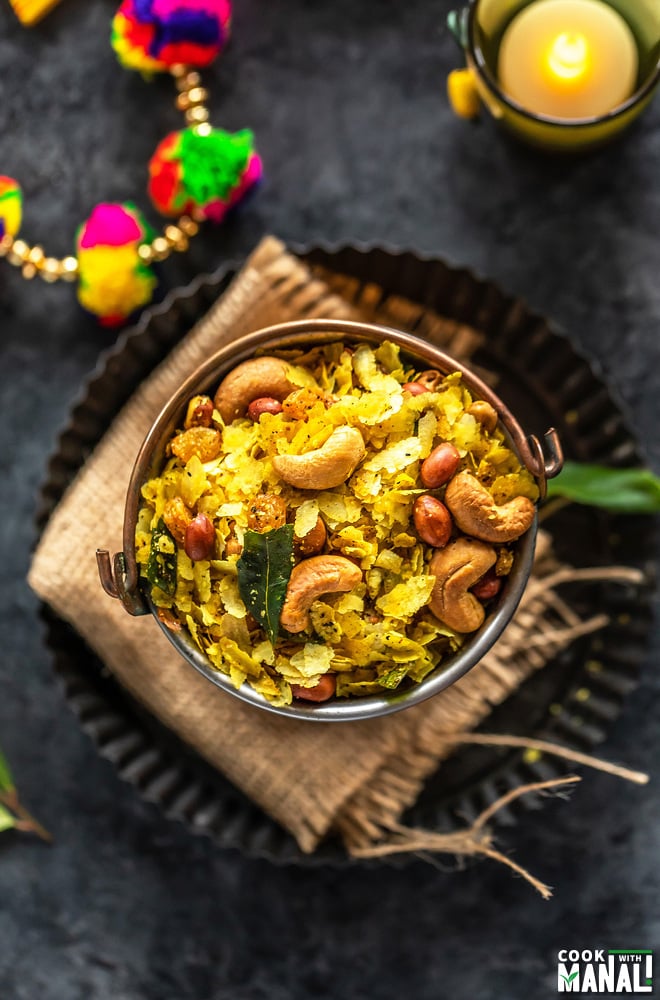 overhead shot of poha chivda served in a copper balti dish