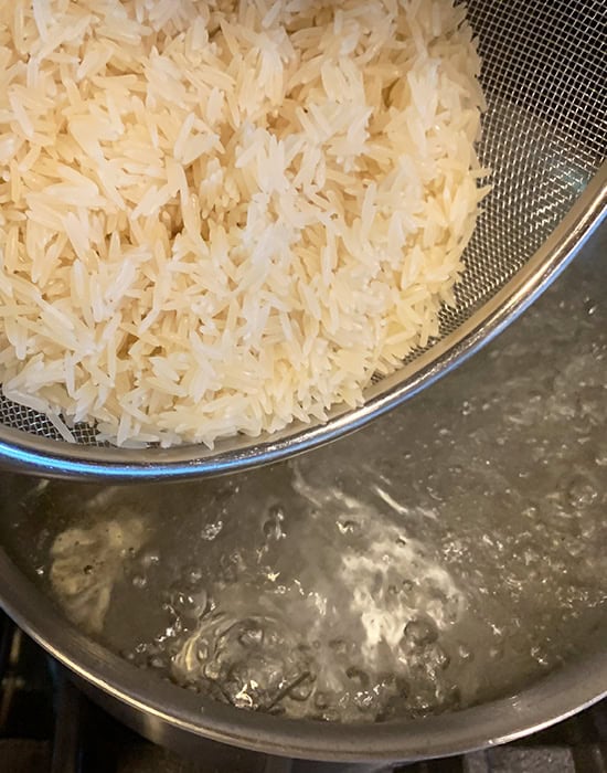 adding rice to pot of boiling water