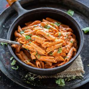 makhani pasta served in a black skillet with a spoon