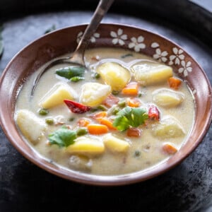 vegetable coconut stew in a serving bowl with a spoon