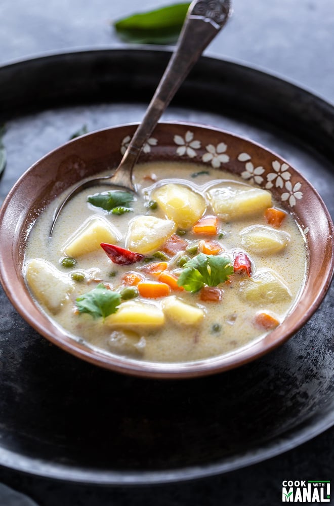 vegetable coconut stew in a serving bowl with a spoon