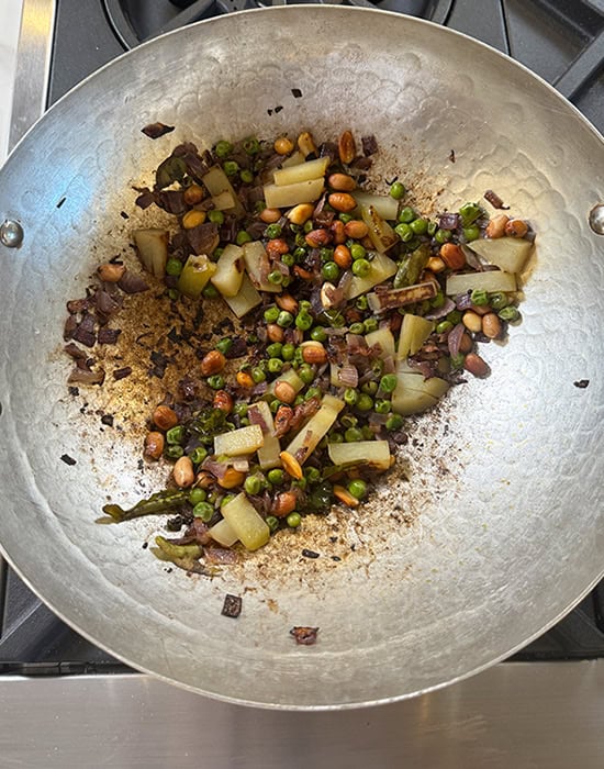 cooked potatoes and peas in a kadai