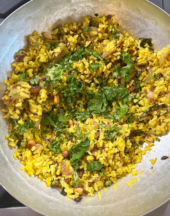poha in a kadai garnished with cilantro