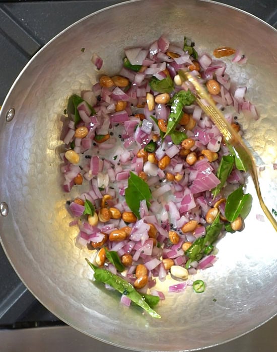 sauteed onions with curry leaves and peanuts in a pan