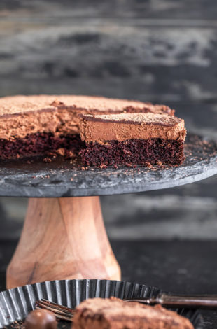 slice of eggless chocolate mousse cake placed on a black cake stand with another slice placed in a plate
