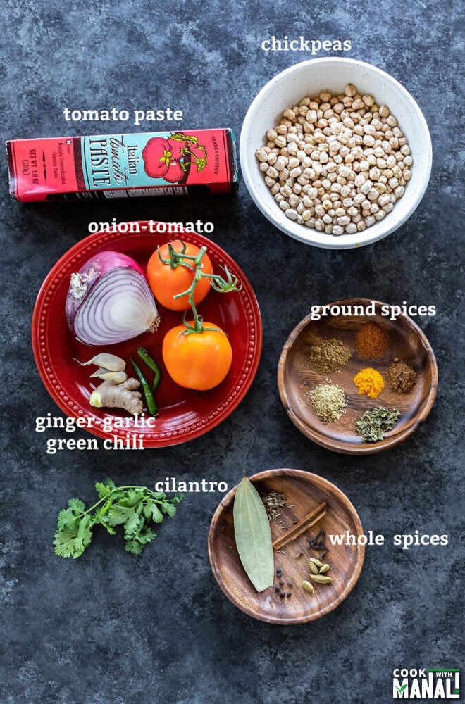 ingredients to make chana masala arranged on a board