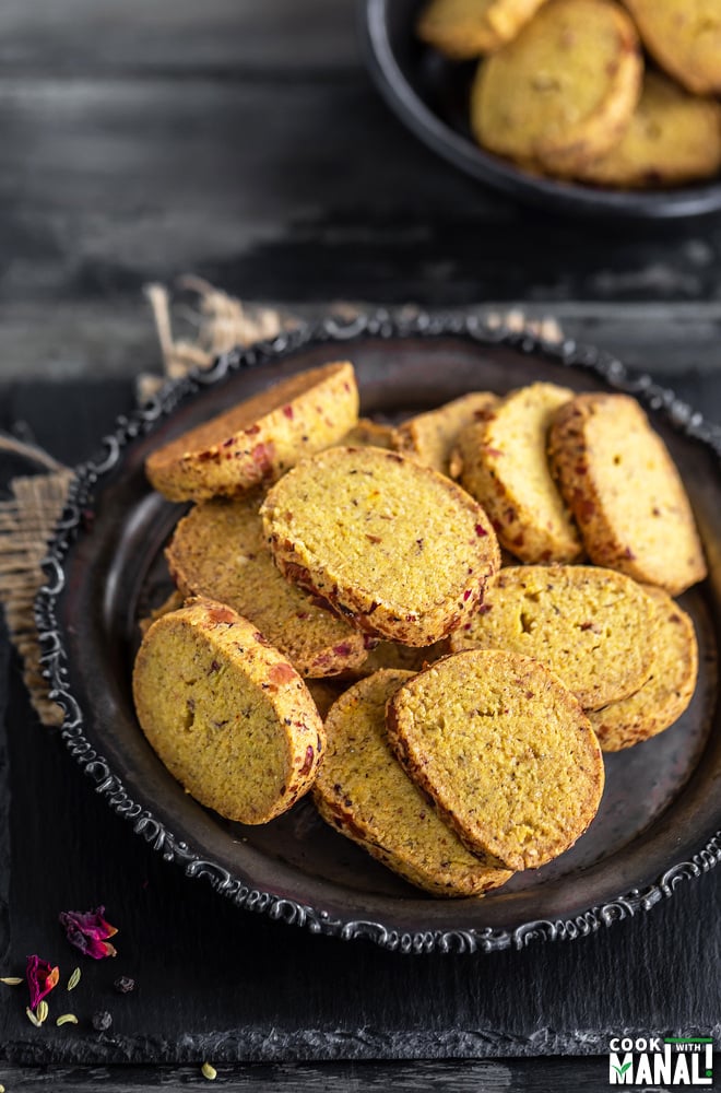 cookies arranged on a plate with another bowl full of cookies placed in the background