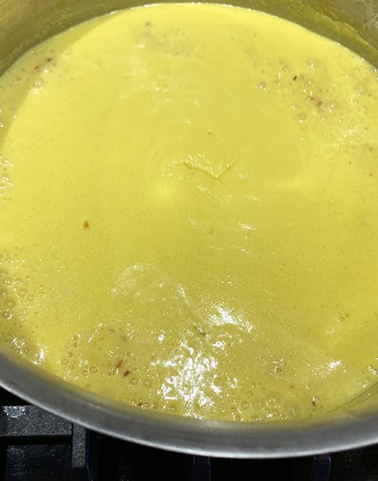 boiling kadhi in a steel pot