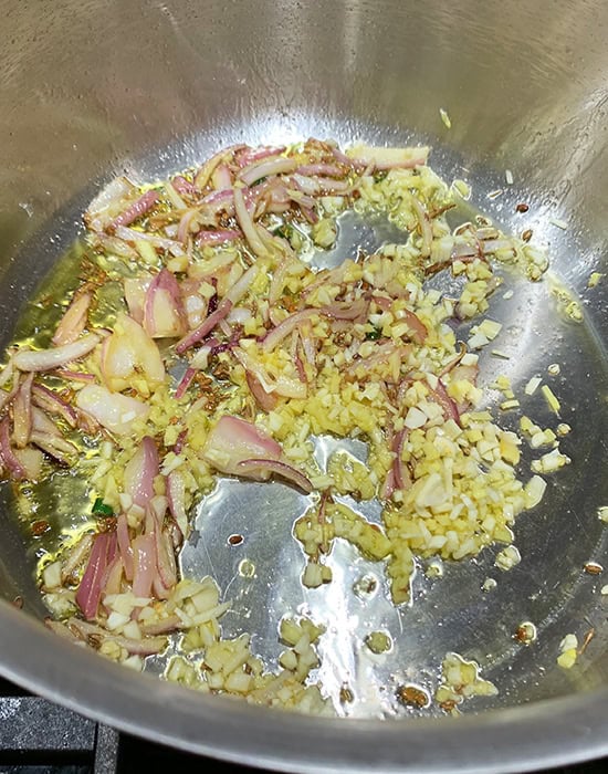 chopped ginger garlic and onions in tadka in a steel pot