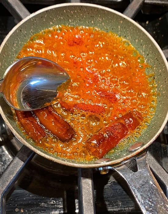 tadka of red chili powder, dried chilies and cumin seeds
