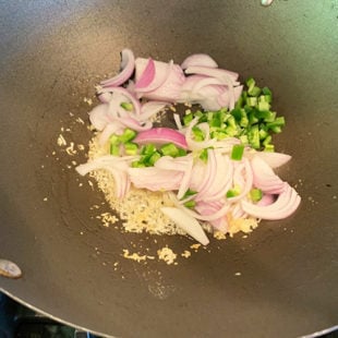 sliced onion, chopped jalapeno and grated garlic in a wok