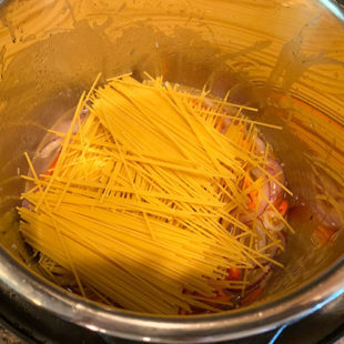 spaghetti noodles arranged in a criss-cross manner in instant pot