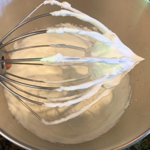 wire whisk attachment of stand mixer with whipped cream