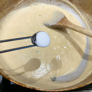 1/2 teaspoon of salt being added to a smooth paste in a wok