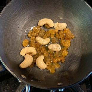 a small pan filled with cashews and golden raisins