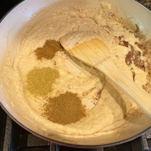 ground spices added to a pan with ground paste