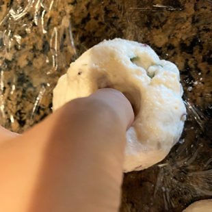medu vada being shaped by inserting a thumb in the center