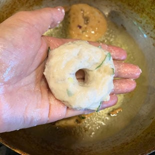 shaped medu vada placed on a palm