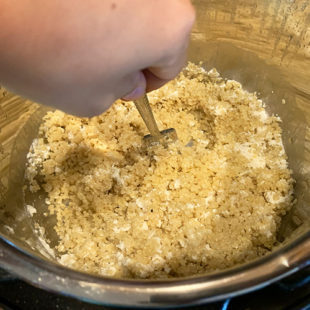 quinoa being fluffed with a fork after cooking