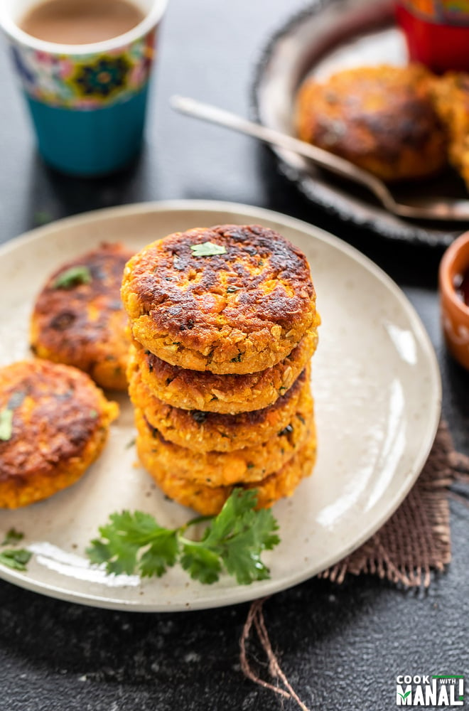 stack of 5 sweet potato oats tikki with glass of chai placed in the background