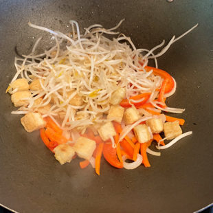 sliced carrots, peppers, bean sprouts in a wok