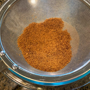 jaggery powder in a strainer