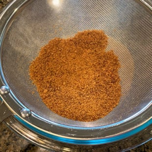 jaggery powder in a strainer