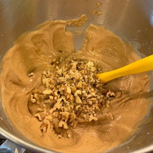 walnuts being folded with a spatula into a batter