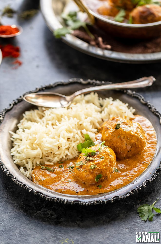 plate of rice with baby potato curry and a spoon placed on the side