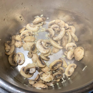 mushrooms and garlic in a steel pot