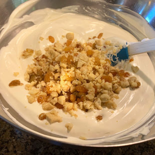 cashews and raisins being added to an ice cream base