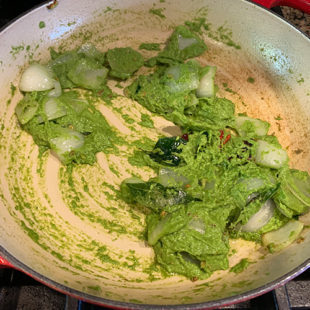 green color paste mixed with onions in a pan