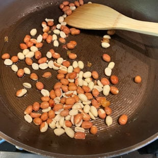 peanuts in a pan with a spatula