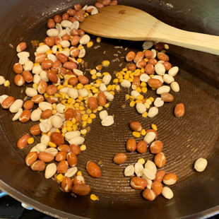 peanuts with chana dal being roasted in a pan