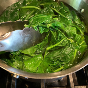 wilted spinach leaves in a pan