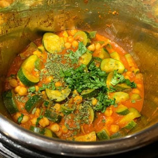 zucchini and chickpea in a tomato based curry garnished with cilantro