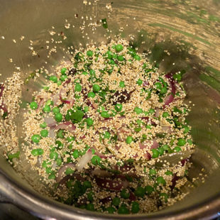 quinoa, green peas, cilantro and spices mixed together in a pot