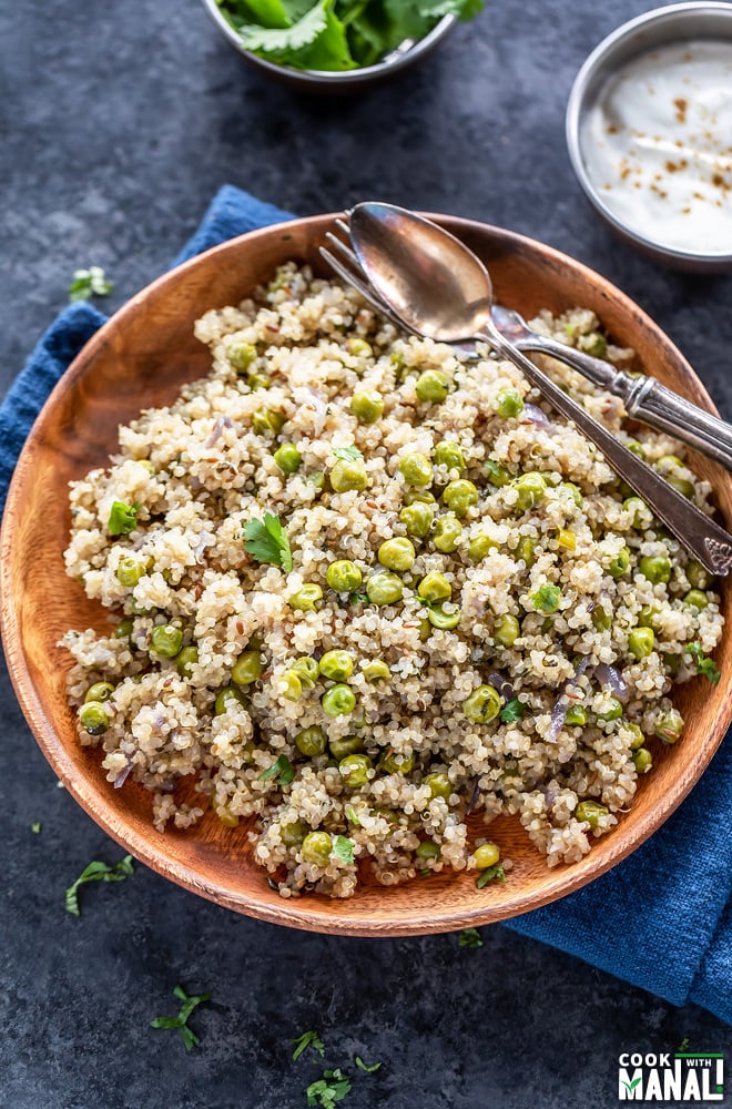 plate of quinoa with green peas and a bowl of yogurt placed in the background