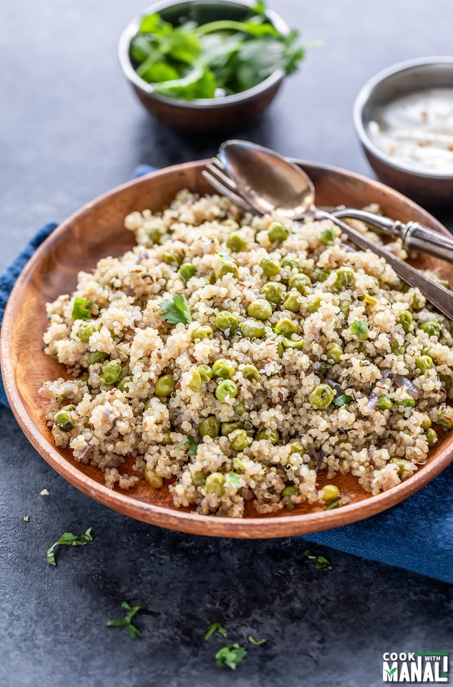 plate of quinoa with green peas and a bowl of yogurt placed in the background