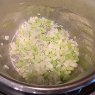 onion and celery in a steel pot