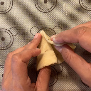 dough being folded to shape it like a cone