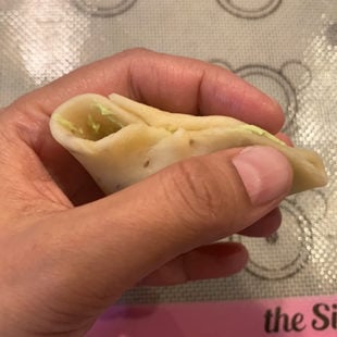 hands pinching a samosa to seal it