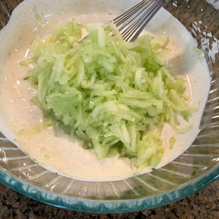 grated cucumber in a bowl of yogurt