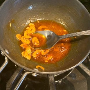 sliced garlic in a small pan with red chili powder